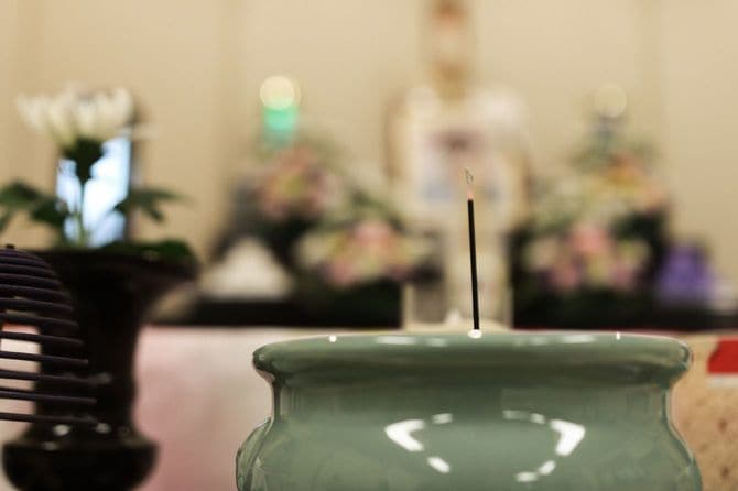 線香にクローズアップされた葬儀の様子