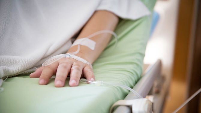 病院のベッドで点滴を受ける子供