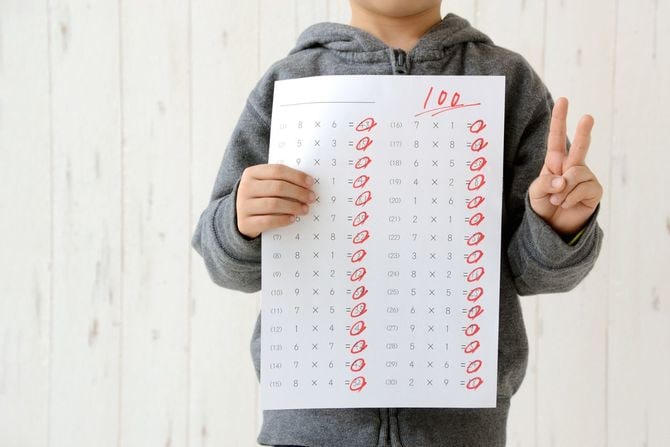 100点のテストを持つ少年