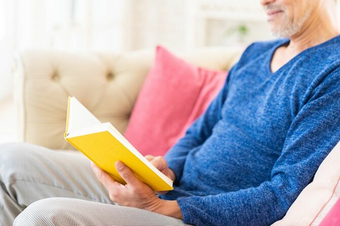 ソファに座り読書をする男性