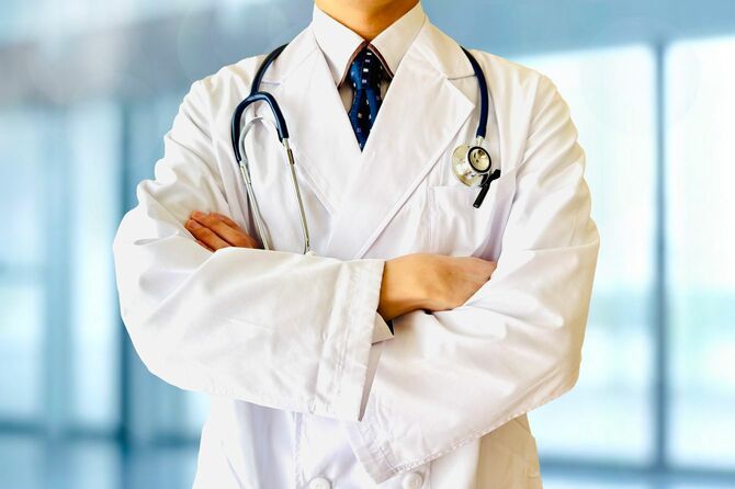 腕を組んで立つ医師