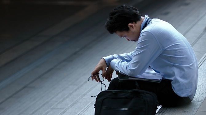 ストレスのたまった男性が階段に腰を下ろす