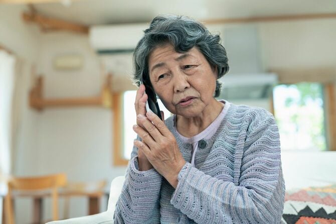 心配そうに電話をかける年配の女性