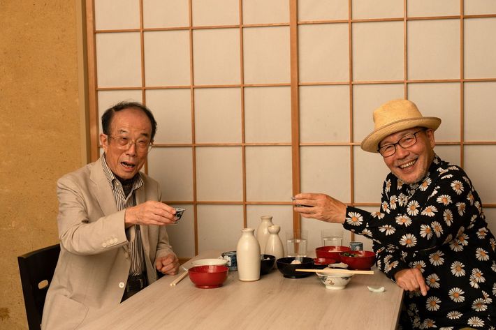 江戸の呑み事情に思いを馳せて乾杯する漫画原作者の久住昌之さん（右）と食文化史研究家の飯野亮一さん。店主が文献や錦絵を紐解いて再現した江戸の酒菜で酌み交わすのは熱燗だ。［出所＝『<a href="https://www.amazon.co.jp/exec/obidos/ASIN/483344075X/presidentjp-22" target="_blank">江戸呑み　江戸の“つまみ”と晩酌のお楽しみ</a>』（プレジデント社）］