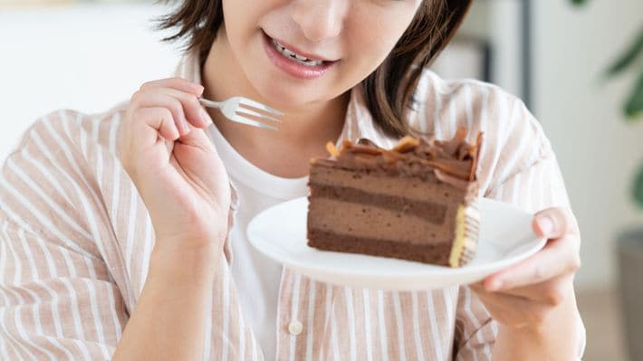 チョコレートケーキを食べている若い女性