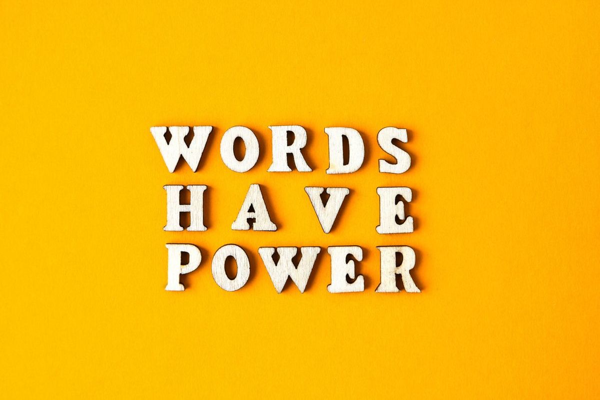 黄色の背景に木製の文字で「WORDS HAVE POWER」