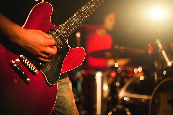 ステージライト付きのライブショーでギターを弾くインディーロックギタリスト