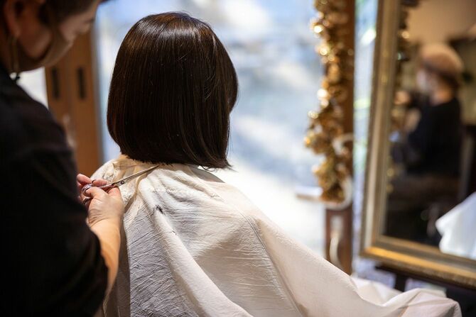 客の髪を切る美容師