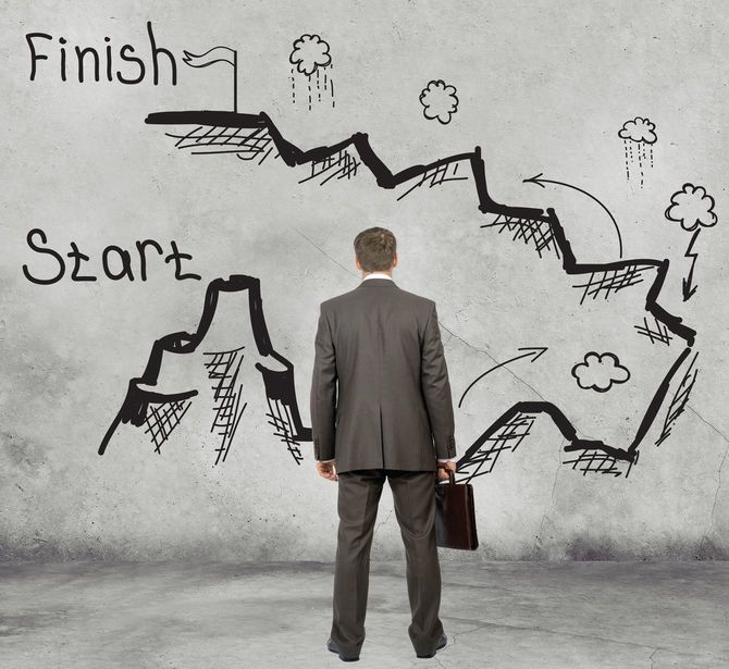 これからゆく険しい道をながめているビジネスマン