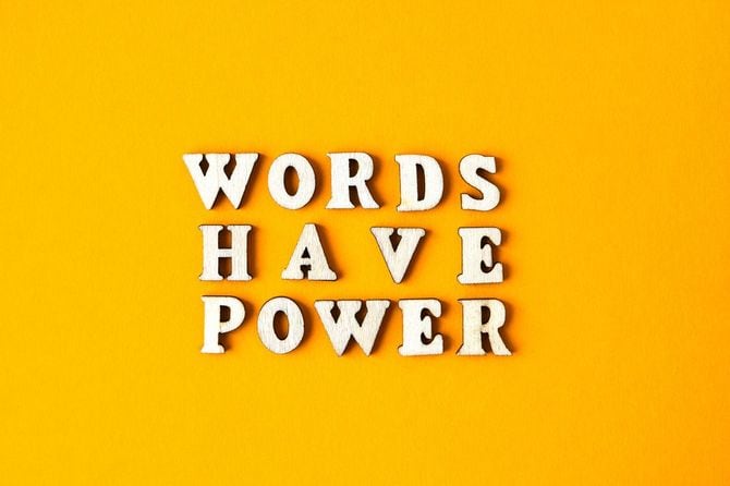 黄色の背景に木製の文字で「WORDS HAVE POWER」