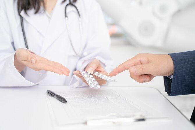 処方薬を説明する女性医師と男性患者
