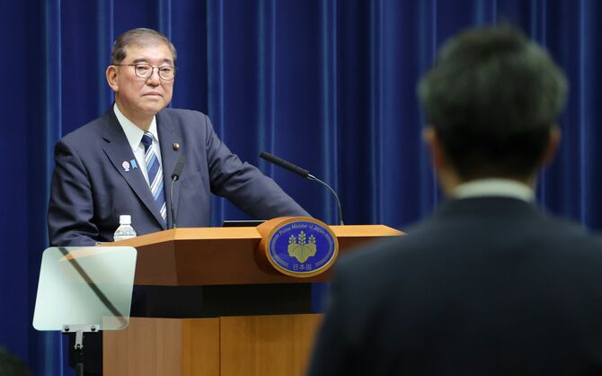 記者会見で、質問を受ける石破茂首相（奥）