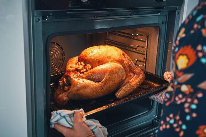  サンクスギビングのディナーで食べるターキーをオーブンから取り出す手元