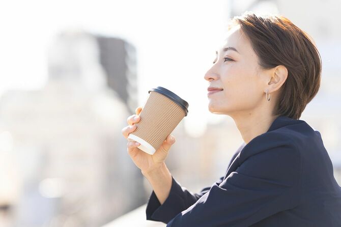 屋上でコーヒーを飲んでいる女性