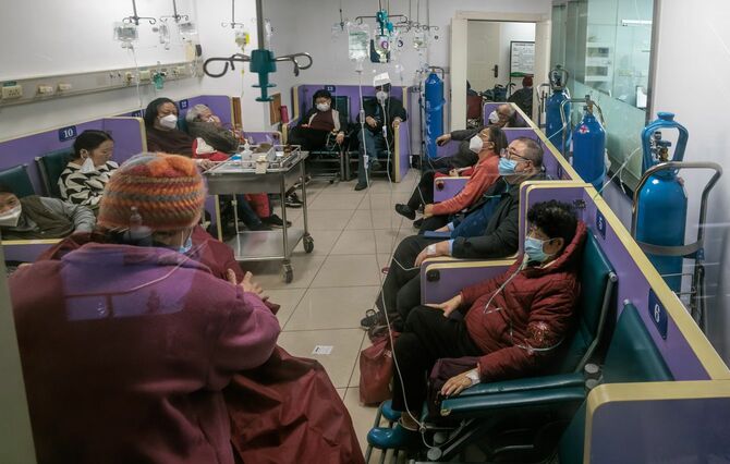 病院の廊下で、新型コロナウイルスの治療を受ける人々