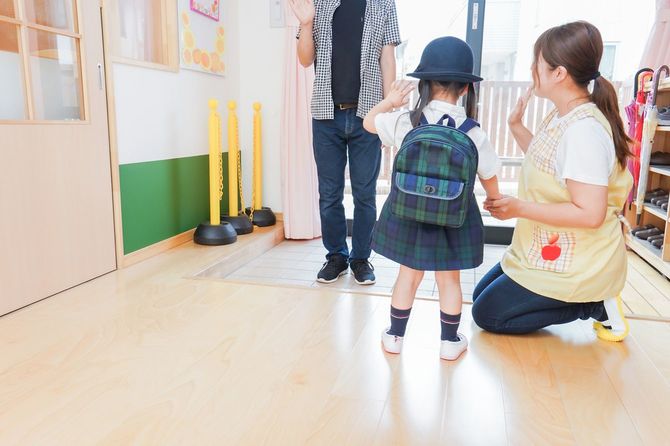 子供を迎えに来た親と見送る保育士