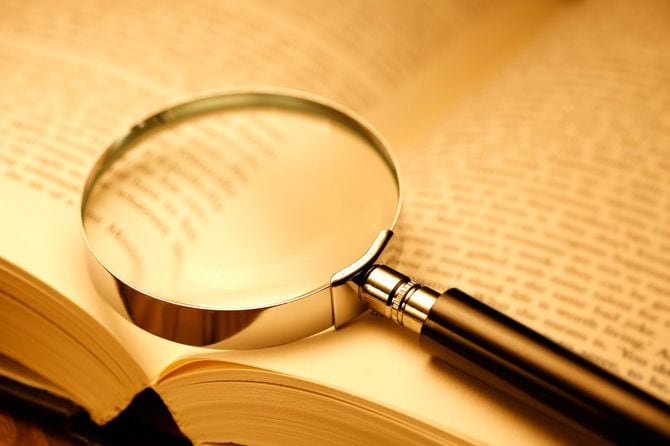 ひらいた本の上の虫眼鏡