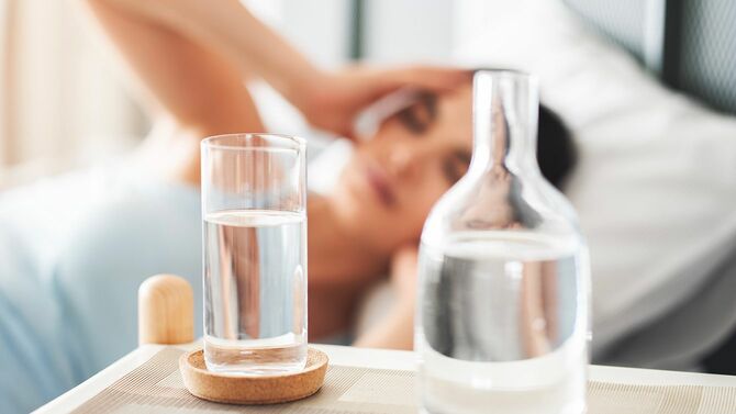 頭を押さえる女性と水