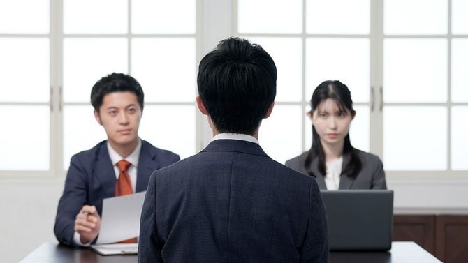 2人の面接官と面接をするビジネスパーソン
