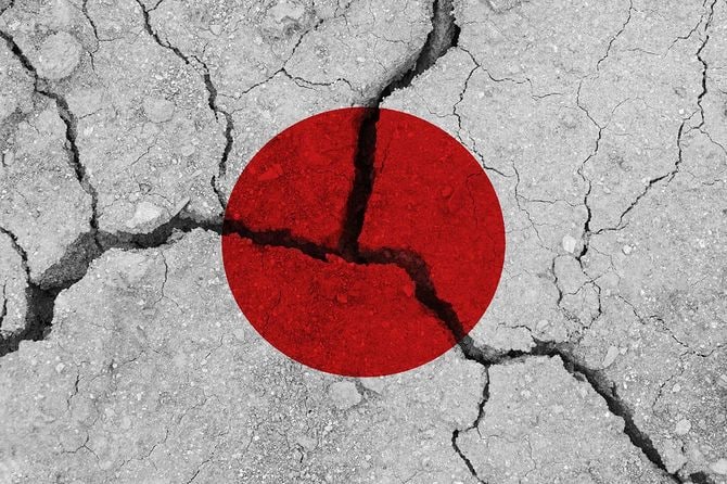 ひび割れた地面に重ねられた、日本の国旗