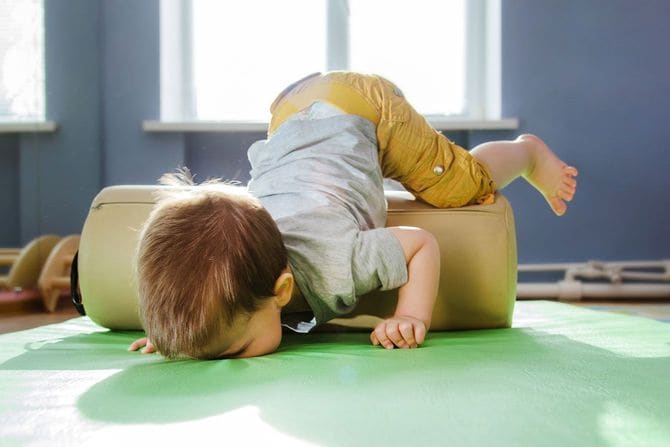 フォームローラーで遊んでいるうちにマットの上に顔から落ちる子供