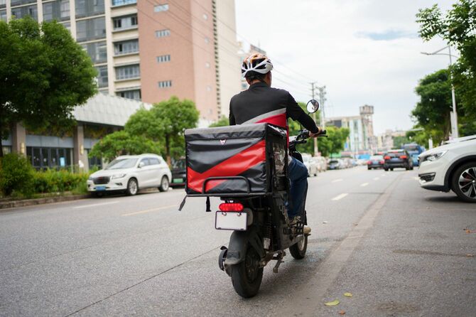 バイクに乗るフードデリバリーの配達員