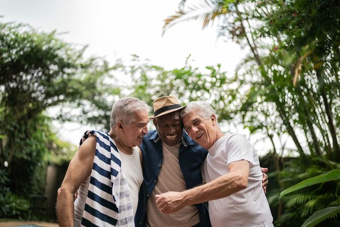 笑顔で抱き合う3人の高齢の男性
