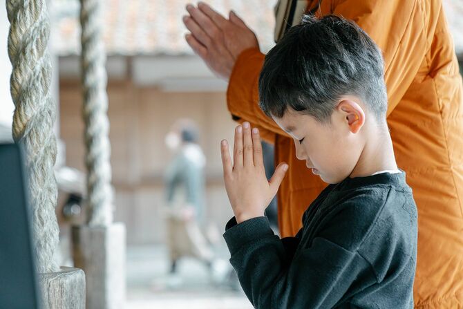 日本のお寺で祖父と一緒に祈る少年。岡山県, 日本