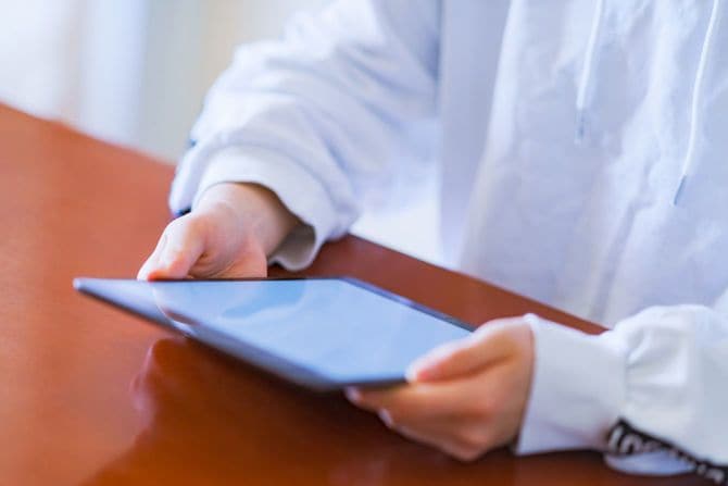 リビングでタブレットを使用する子供