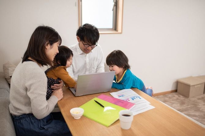 家族四人で楽しくノートパソコンに向かっている