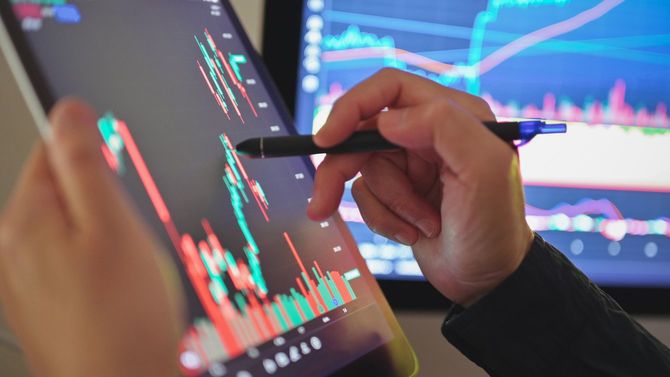 タブレット端末でも株価をチェックしている手元