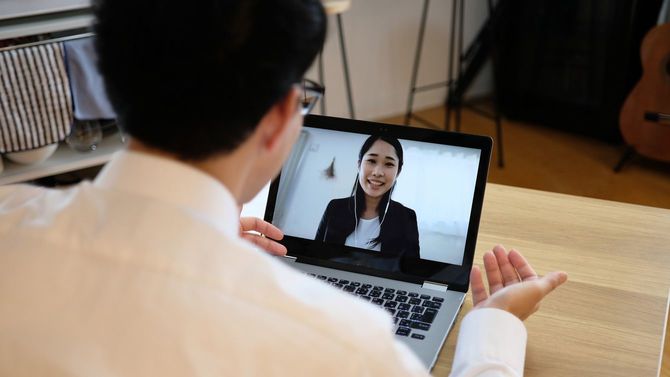 ウェブ会議で同僚と話すアジアのビジネスマン