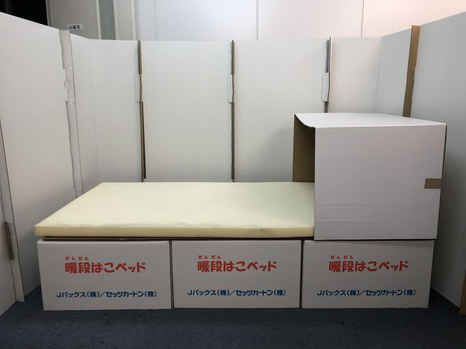 Jパックスが開発した段ボールベッド「暖段はこベッド」。感染症対策用にフードが付いている。