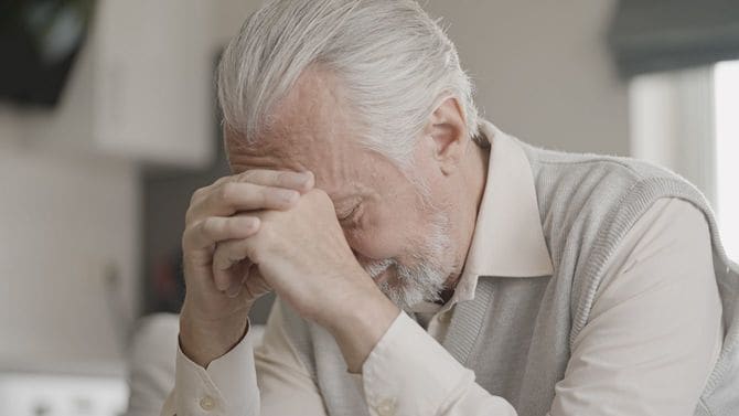 うつむくシニア男性