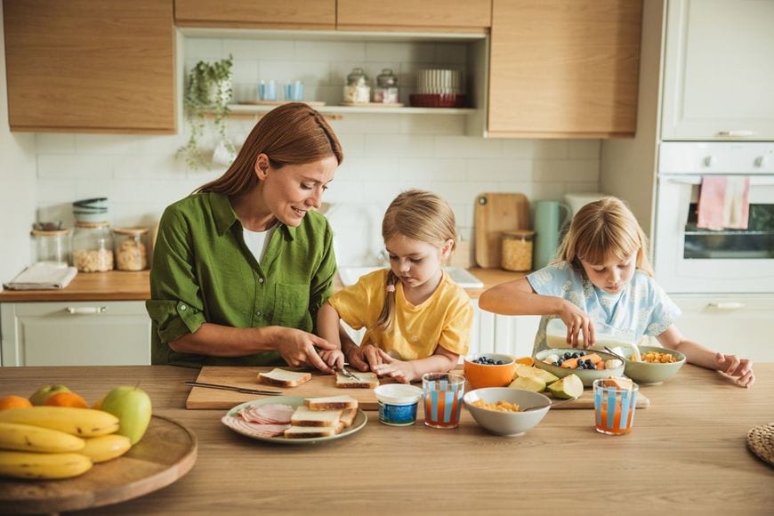 娘と一緒に朝食を準備する母親