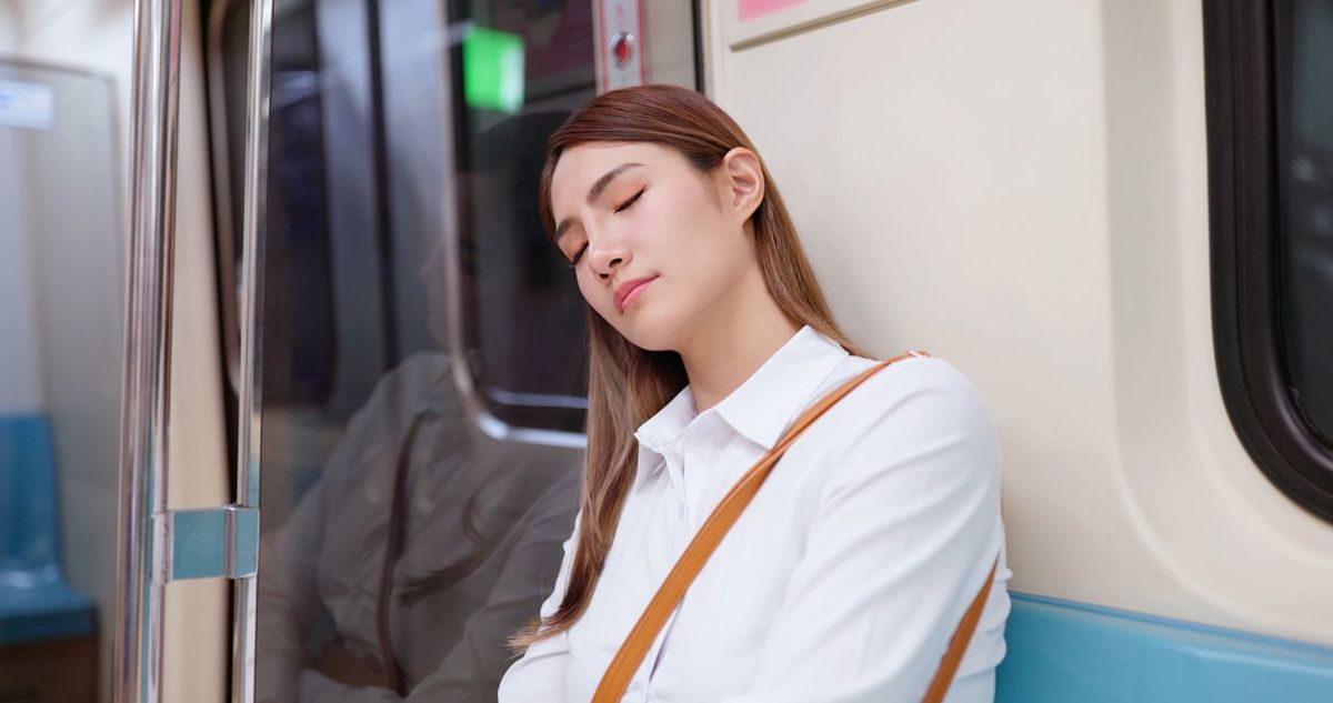 地下鉄の車の中で眠る女性