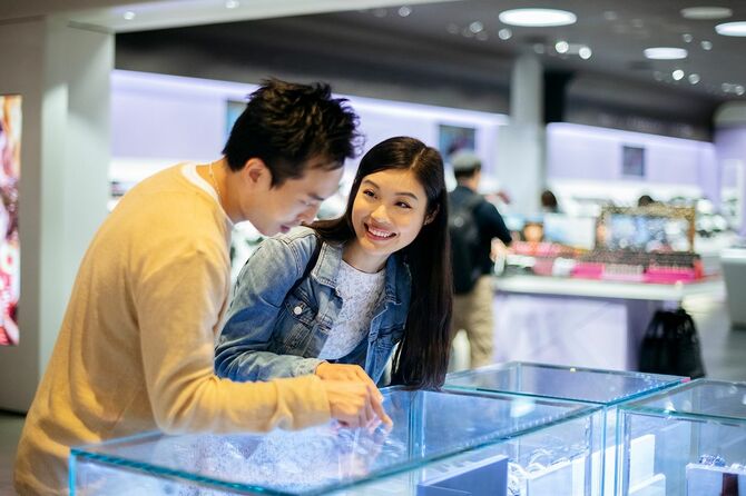 モールの店のカウンターを見ている若いアジアのカップル