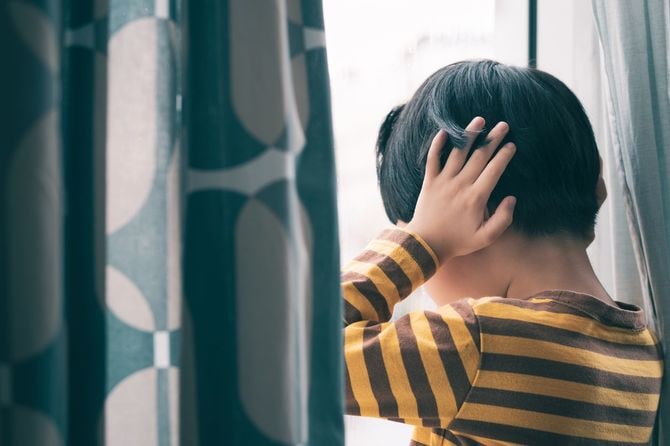 耳をふさぐ少年