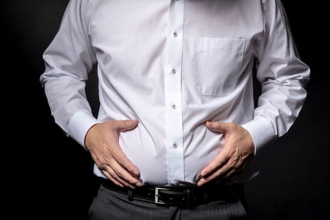 太った腹を気にする男性