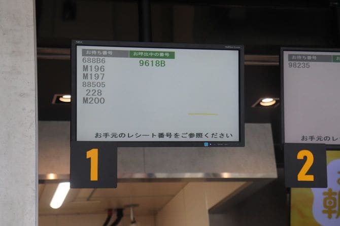 商品カウンター上の「オーダーメニューボード」。モバイルオーダーの注文分はMから始まる番号で表示される。