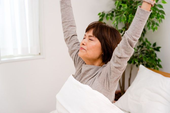 寝室のベッドで目を覚ます50代女性