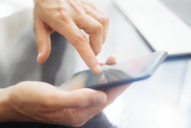 スマートフォンを操作する男性の手