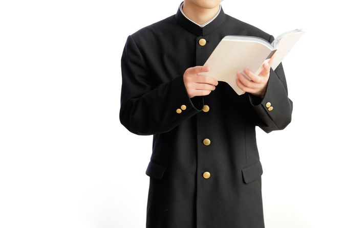 教科書をもって立っている男子生徒