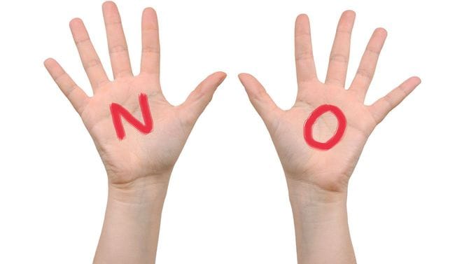 「NO」と書かれた手のひら