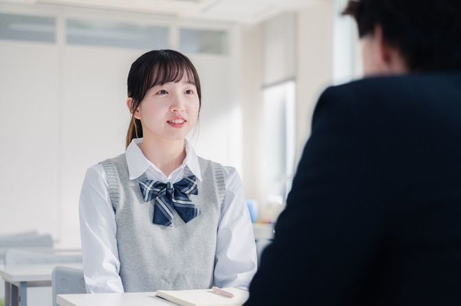 面接で進路指導を受ける女子高生