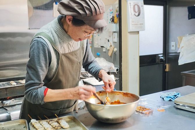 お客さんの対応をしながら団子を焼いて、忙しそうに働く昭美さん