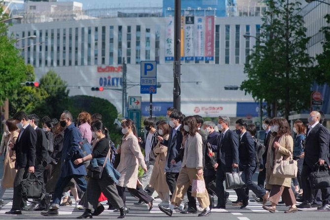 都市部の横断歩道を渡る大勢の通勤者