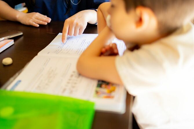 幼児の読み書き練習を手伝う教師
