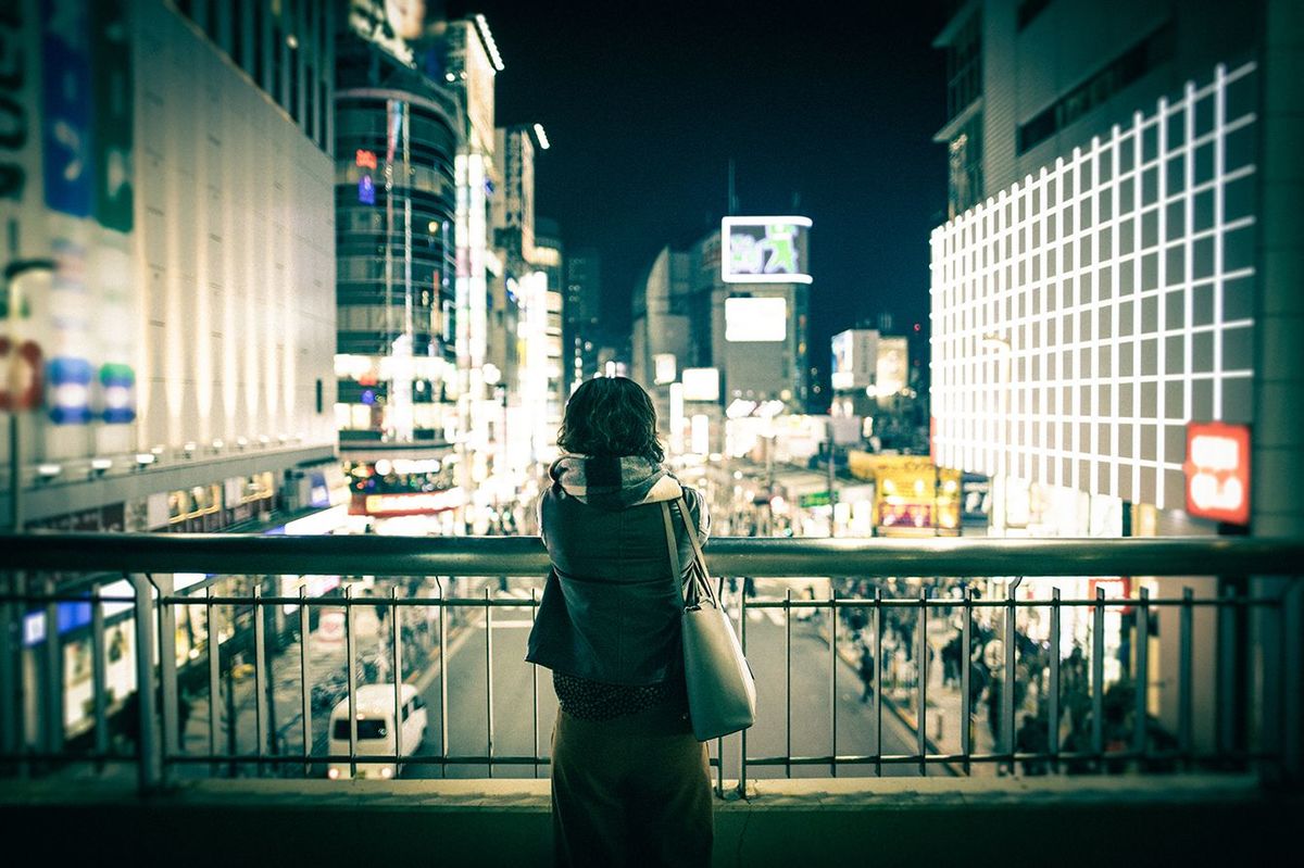 都会の夜景を眺めている若い女