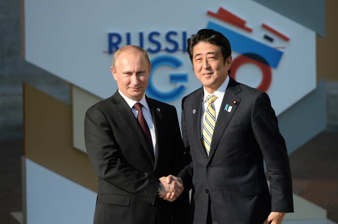 ロシアのプーチン大統領（左）と握手する安倍晋三首相（当時）